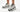 Woman wearing New Balance 9060 Reflection Black women’s sneakers in a clean white lifestyle studio setting