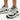 Woman wearing New Balance 9060 Reflection Black women’s sneakers in a clean white lifestyle studio setting