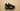 Black and metallic gold Air Jordan sneaker floating on a warm tan studio background showcasing premium Jordan basketball and lifestyle footwear for men.
