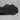 New Balance black sneaker outsole bottom view showing tread pattern on grey textured studio background
